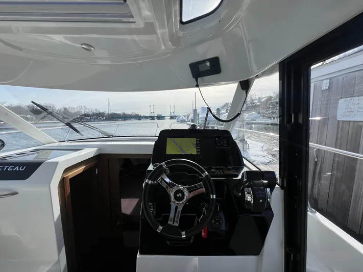 Yacht Photos Pics Interior view of 2020 Beneteau Antares 9 boat cockpit with steering wheel and navigation system.
