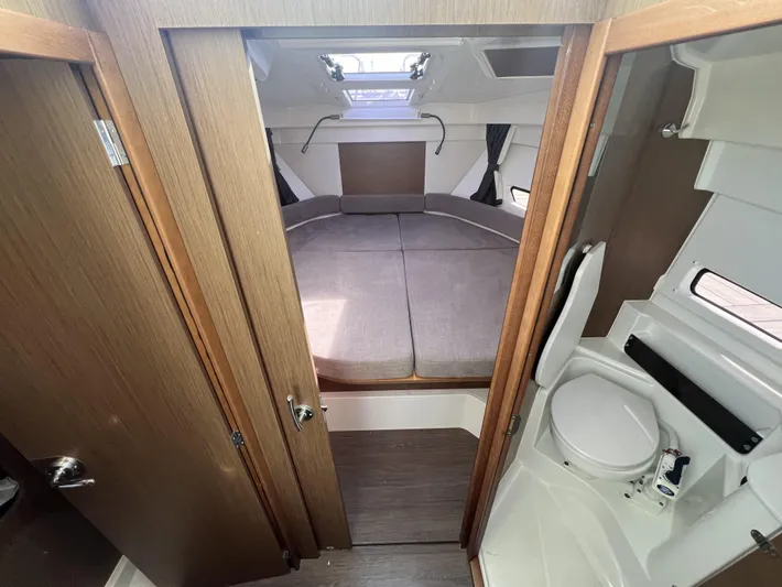  Yacht Photos Pics 2020 Beneteau Antares 9 cabin interior with bed and compact bathroom.