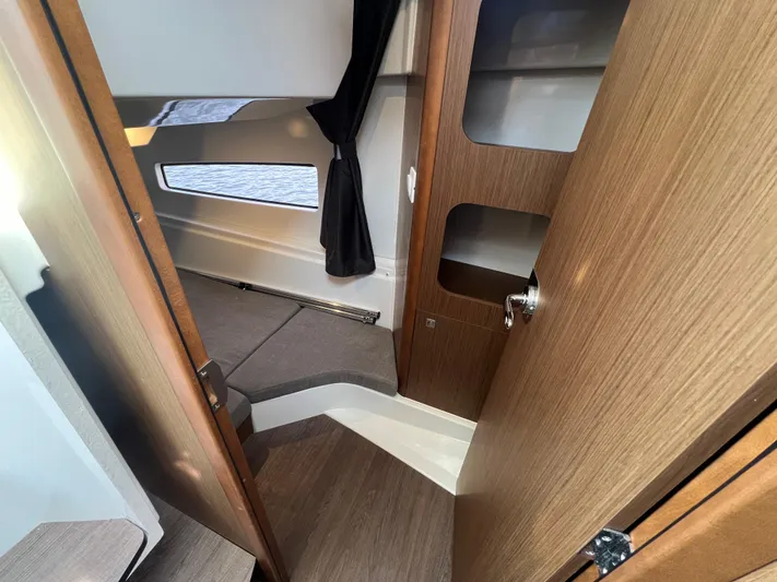  Yacht Photos Pics Interior view of 2020 Beneteau Antares 9 cabin with wood finish and window.