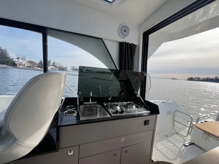  Yacht Photos Pics 2020 Beneteau Antares 9 interior with kitchenette, overlooking serene water view.