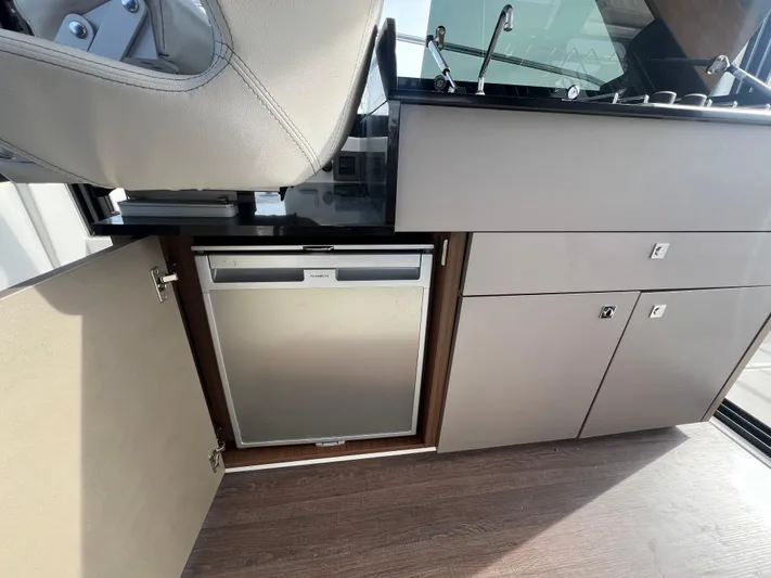  Yacht Photos Pics Interior of 2020 Beneteau Antares 9 with compact fridge and modern cabinetry.