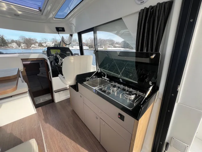  Yacht Photos Pics 2020 Beneteau Antares 9 interior with modern kitchen and steering area.