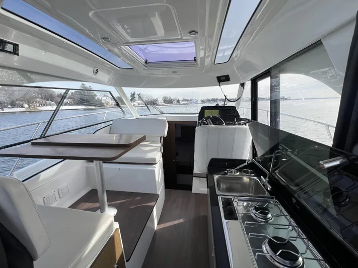  Yacht Photos Pics Interior of 2020 Beneteau Antares 9 boat with modern kitchen and seating area.