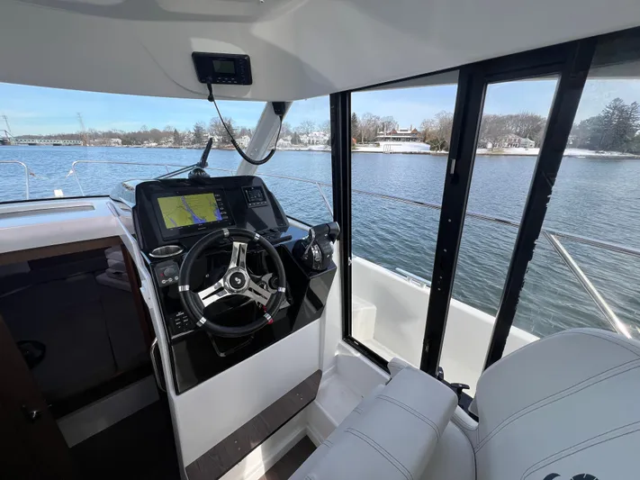 Yacht Photos Pics Interior view of 2020 Beneteau Antares 9 boat cockpit with steering wheel and navigation system.