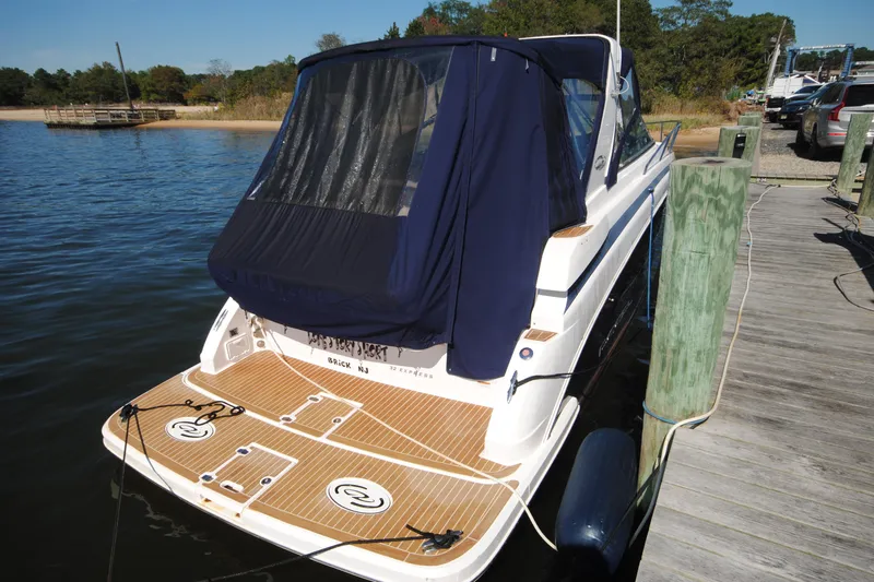  Yacht Photos Pics 2015 Regal 32 Express boat docked with covered deck, wooden platform, and scenic background.