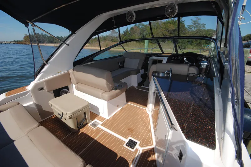  Yacht Photos Pics 2015 Regal 32 Express boat interior with seating, kitchenette, and steering area on a sunny day.