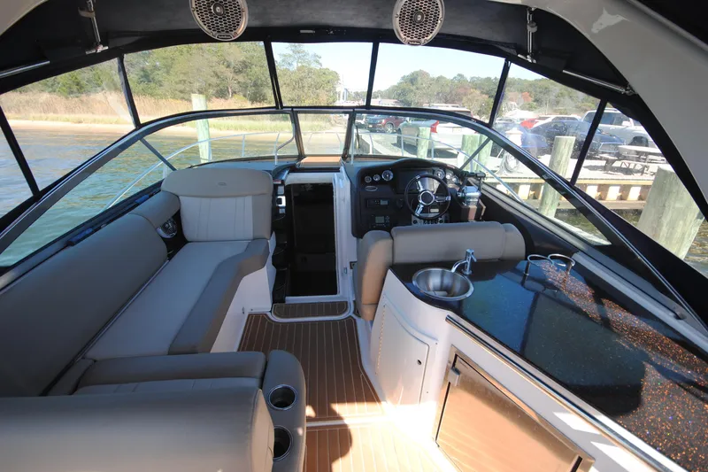  Yacht Photos Pics Interior of 2015 Regal 32 Express boat with seating, steering wheel, and kitchenette.