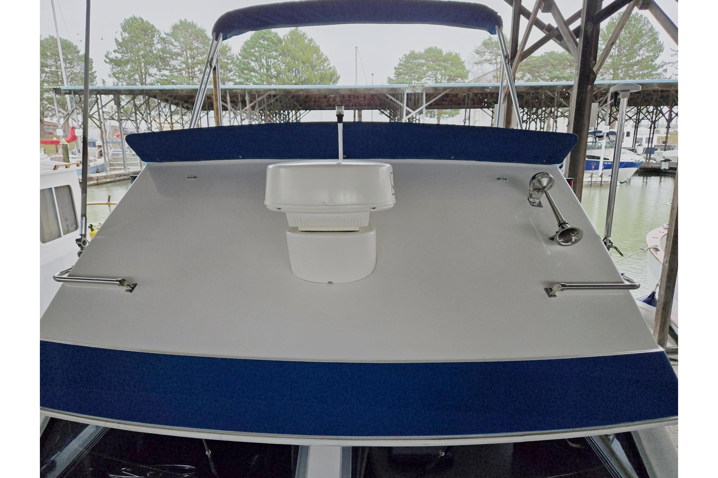 2001 Commander Flybridge Sedan boat docked in marina, front view.