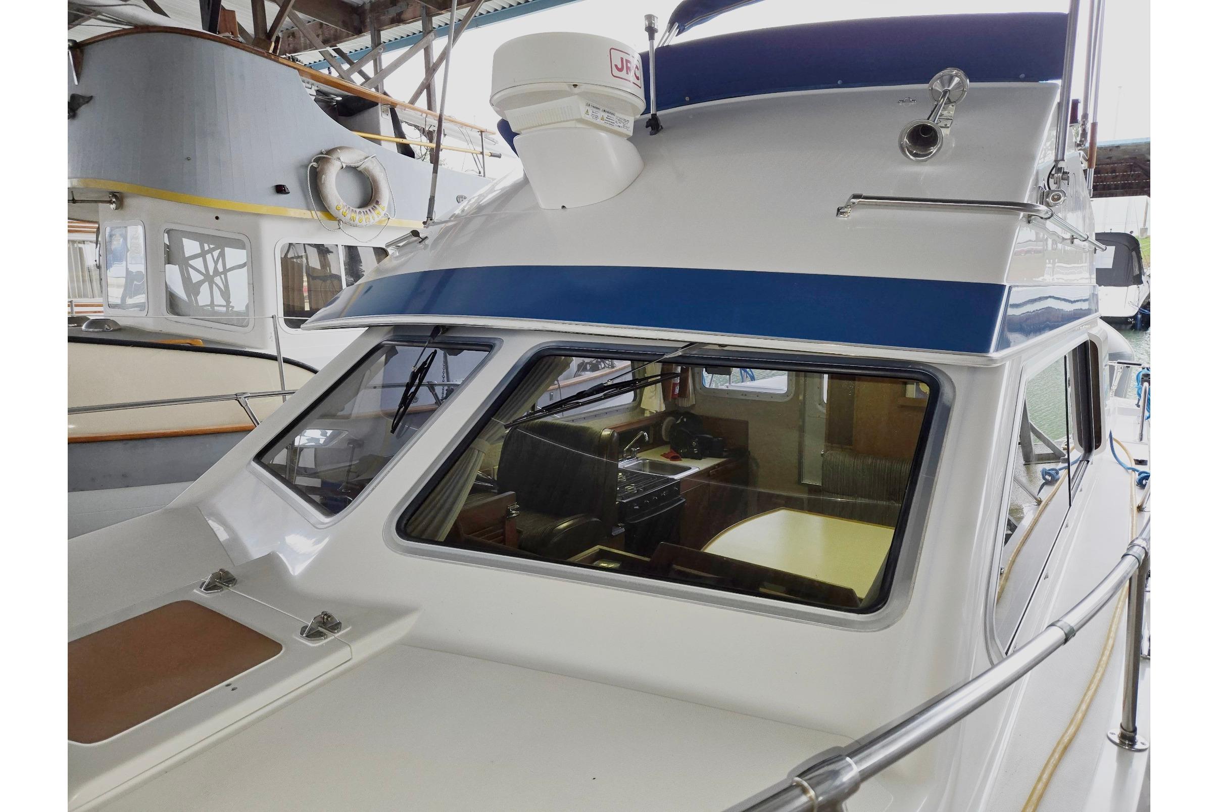 2001 Commander Flybridge Sedan boat docked in a marina, showcasing its cabin and exterior design.