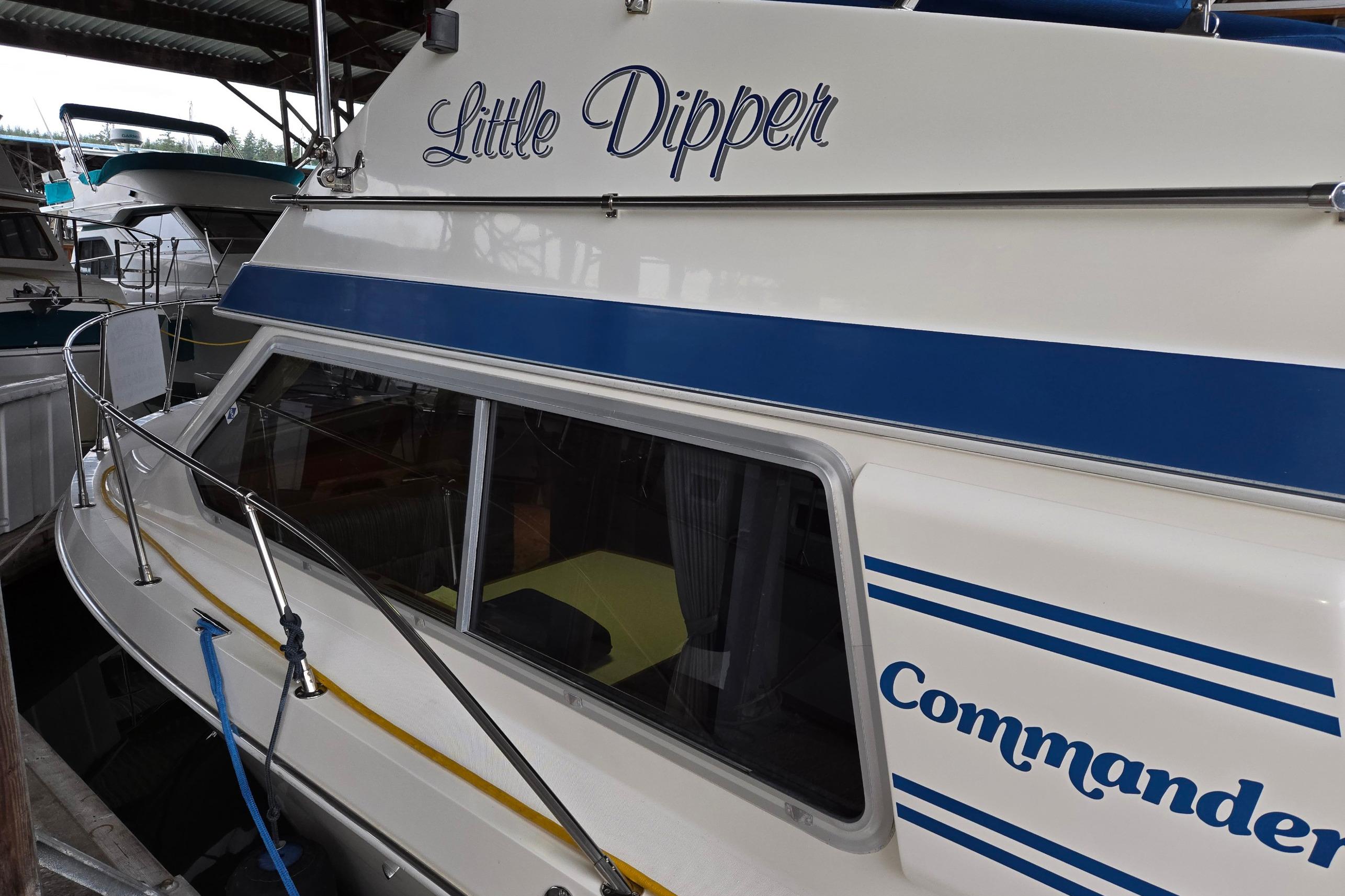 2001 Commander Flybridge Sedan boat named "Little Dipper" docked in a marina.
