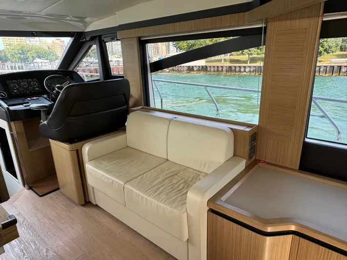  Yacht Photos Pics Interior of 2017 Absolute 50 Fly yacht with beige seating and helm, overlooking water.