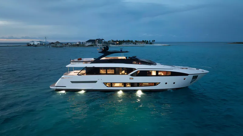 Kiyomizu Yacht Photos Pics Luxurious 2020 Riva 90 Argo yacht illuminated on serene ocean waters at dusk.