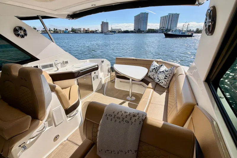  Yacht Photos Pics Luxurious 2022 Sea Ray Sundancer 320 yacht interior with plush seating and scenic waterfront view.
