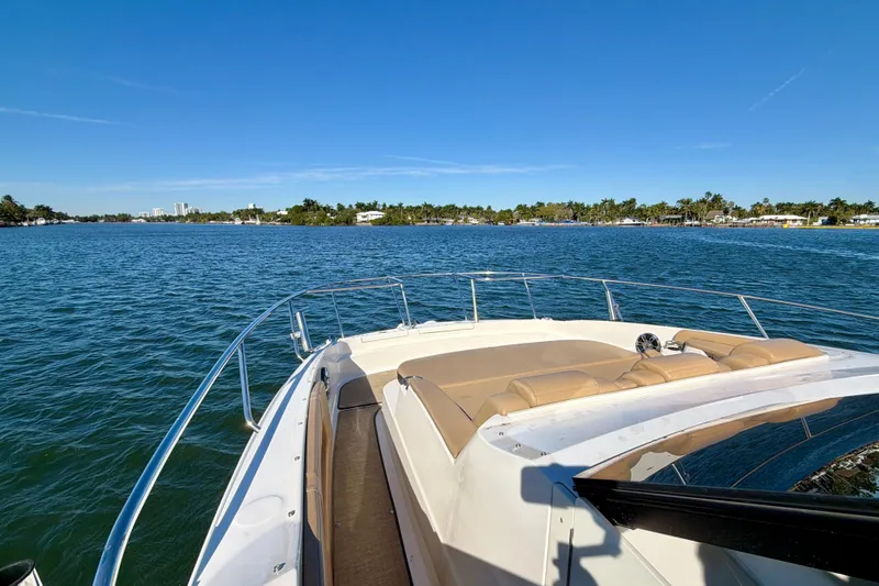  Yacht Photos Pics 2022 Sea Ray Sundancer 320 cruising on a sunny day, with scenic coastal view.