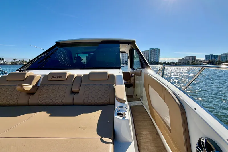 Yacht Photos Pics 2022 Sea Ray Sundancer 320 yacht on sunny water, featuring luxurious seating and city skyline.