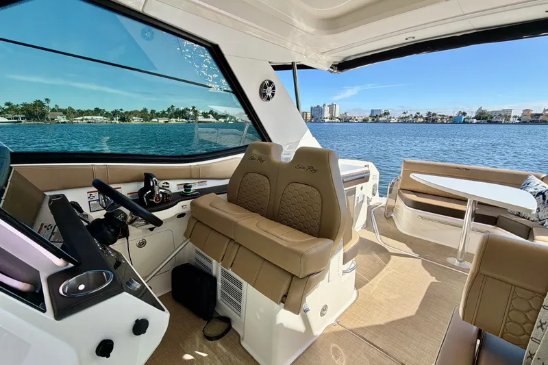  Yacht Photos Pics 2022 Sea Ray Sundancer 320 interior with helm, seating, and waterfront view.