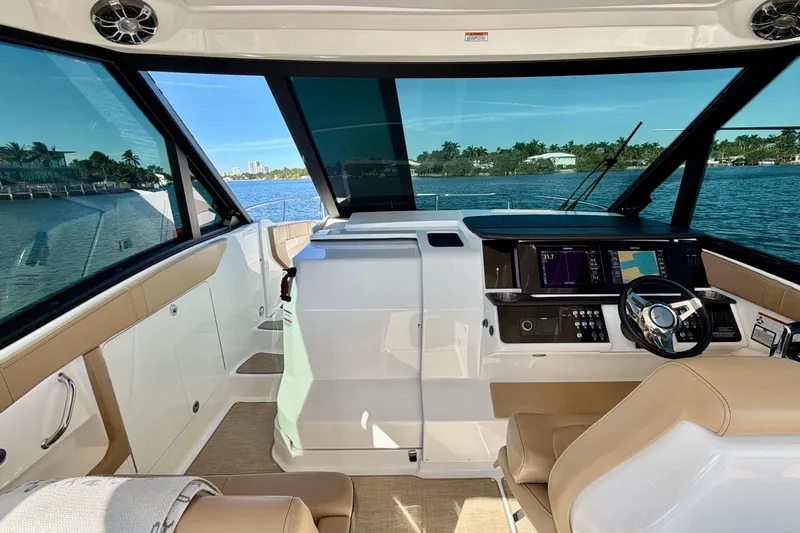  Yacht Photos Pics 2022 Sea Ray Sundancer 320 helm with modern controls, overlooking serene waterfront.