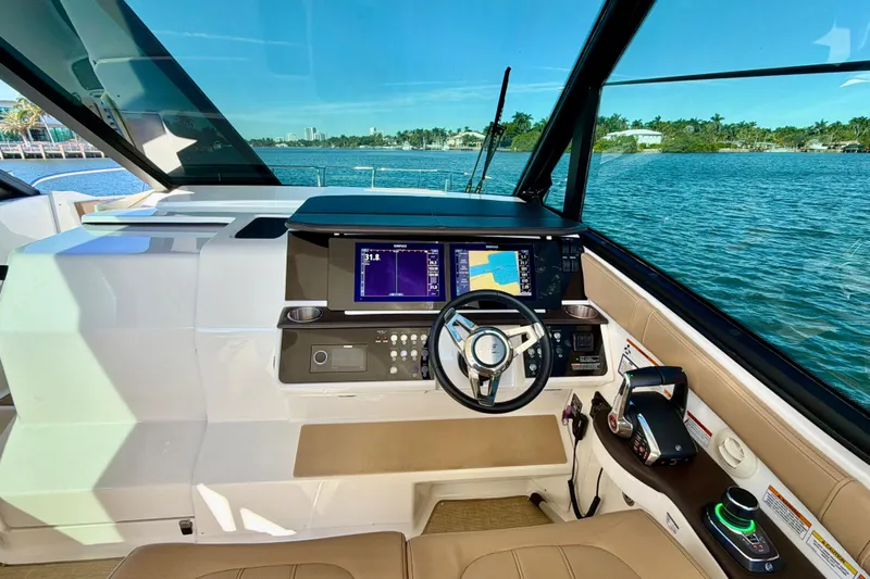  Yacht Photos Pics 2022 Sea Ray Sundancer 320 helm with navigation screens, steering wheel, and waterfront view.