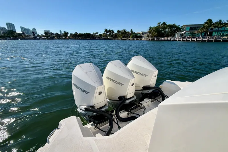  Yacht Photos Pics 2022 Sea Ray Sundancer 320 with triple Mercury outboard engines on a sunny waterfront.