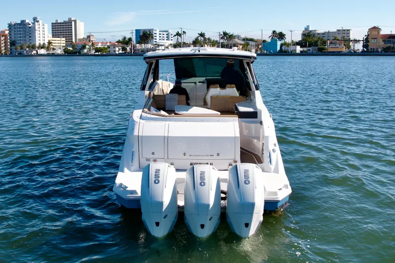  Yacht Photos Pics 2022 Sea Ray Sundancer 320 boat on water, cityscape in background.