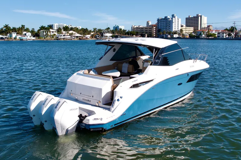  Yacht Photos Pics 2022 Sea Ray Sundancer 320 boat on water, cityscape in background.