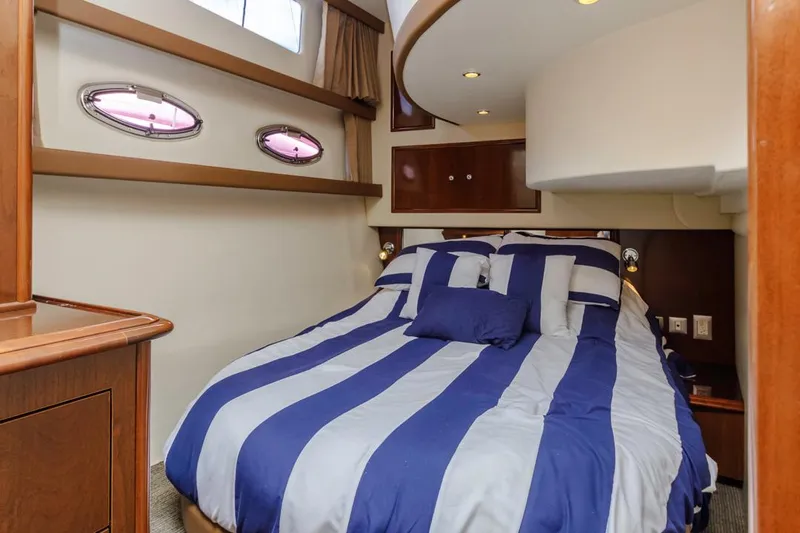 Aloha Ke Akua Yacht Photos Pics Interior of 2007 Carver 42 Super Sport yacht with striped bedding in cozy cabin.