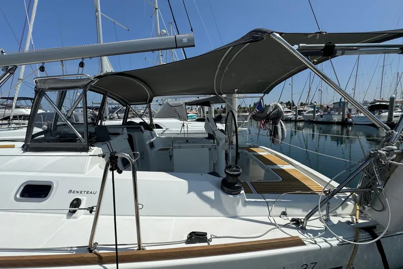 Mi Fuego Yacht Photos Pics 2017 Beneteau Oceanis 37 sailboat docked at marina, featuring shaded cockpit area.