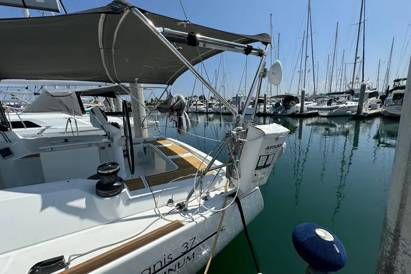 Mi Fuego Yacht Photos Pics Beneteau Oceanis 37 sailboat, 2017 model, docked in a marina with clear blue water.