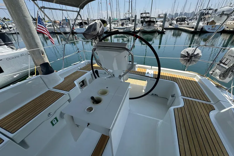 Mi Fuego Yacht Photos Pics Cockpit of 2017 Beneteau Oceanis 37 sailboat docked in marina, featuring steering wheel and seating.