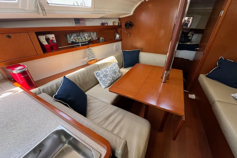 Mi Fuego Yacht Photos Pics 2017 Beneteau Oceanis 37 interior with cozy seating, wooden table, and nautical decor.