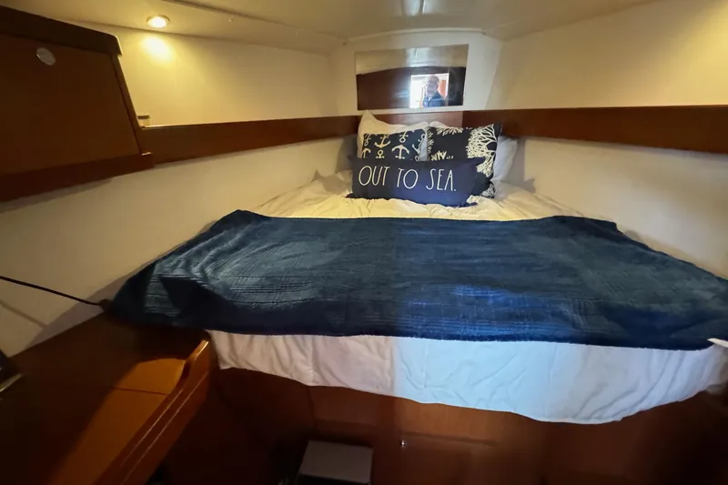 Mi Fuego Yacht Photos Pics Cozy cabin interior of 2017 Beneteau Oceanis 37 sailboat with nautical-themed bedding.