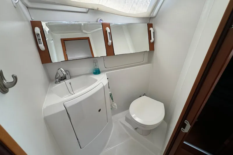 Mi Fuego Yacht Photos Pics Bathroom interior of 2017 Beneteau Oceanis 37 yacht, featuring sink, mirror, and toilet.