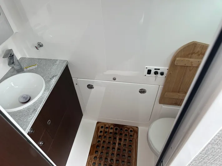  Yacht Photos Pics 2023 Everglades 395 Center Console bathroom with sink, toilet, and wooden mat.