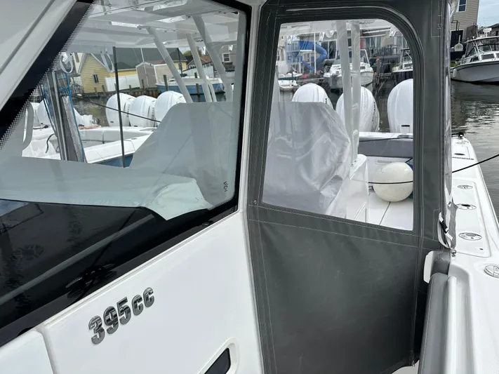  Yacht Photos Pics 2023 Everglades 395 Center Console boat docked, showcasing the cockpit and seating area.