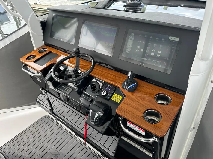  Yacht Photos Pics 2023 Everglades 395 Center Console helm with advanced navigation displays and wooden dashboard.