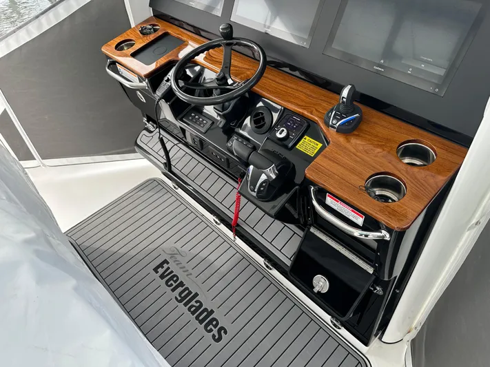  Yacht Photos Pics 2023 Everglades 395 Center Console boat helm with wooden dashboard and steering wheel.