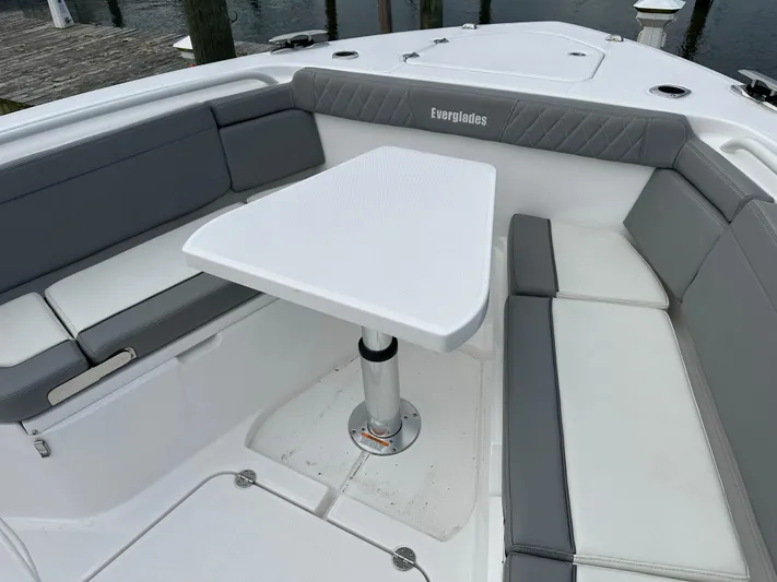  Yacht Photos Pics 2023 Everglades 395 Center Console boat with cushioned seating and table.