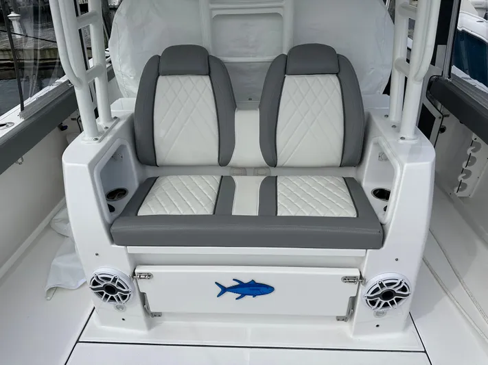  Yacht Photos Pics 2023 Everglades 395 Center Console boat seating with dual speakers and storage compartment.