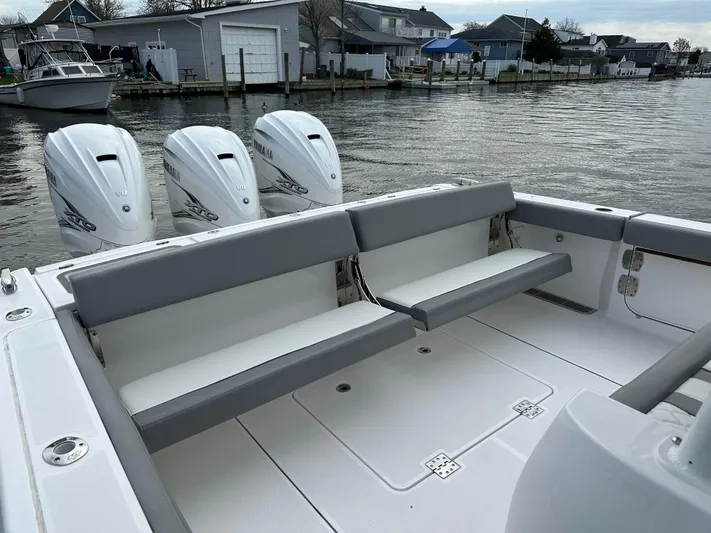  Yacht Photos Pics 2023 Everglades 395 Center Console boat with triple outboard engines docked by waterfront homes.