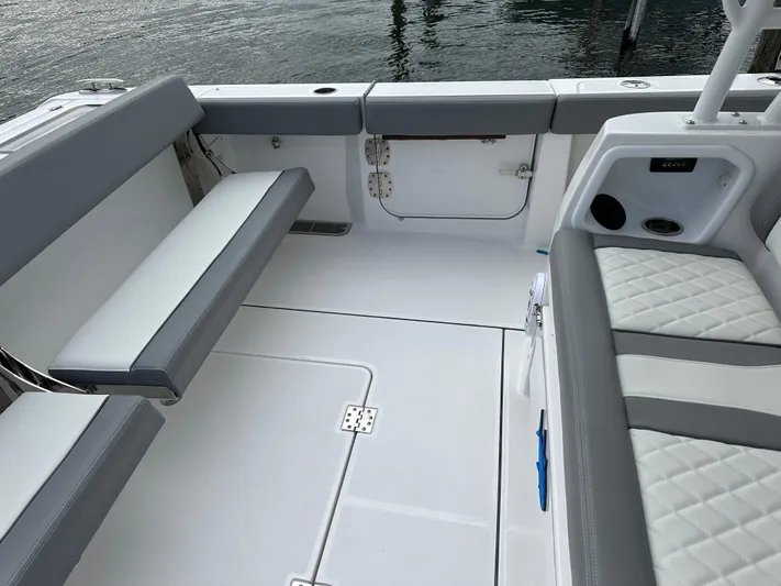  Yacht Photos Pics 2023 Everglades 395 Center Console boat interior with cushioned seating and storage compartments.