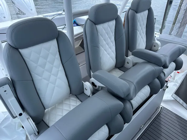  Yacht Photos Pics 2023 Everglades 395 Center Console boat seats, gray and white leather upholstery.