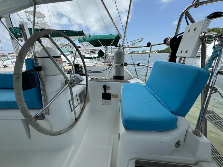 Pelican Pat Yacht Photos Pics Cockpit of 2010 Jeanneau Sun Odyssey 42i sailboat with blue cushions and steering wheel.
