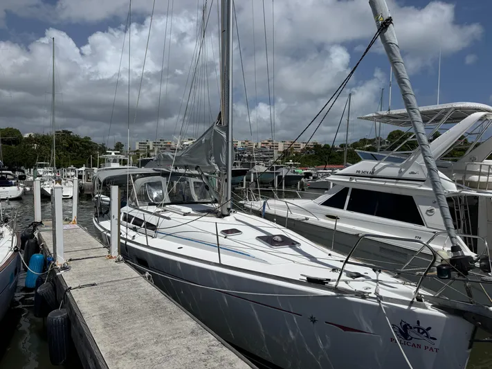 Pelican Pat Yacht Photos Pics Jeanneau Sun Odyssey 42i sailboat docked at marina, 2010 model, under cloudy sky.