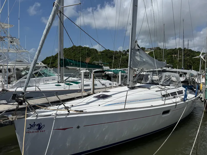 Pelican Pat Yacht Photos Pics 2010 Jeanneau Sun Odyssey 42i sailboat docked at marina, surrounded by lush greenery.