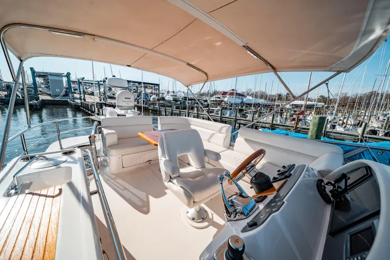  Yacht Photos Pics Flybridge of 2015 Belize 54 Daybridge yacht with helm, seating, and marina view.