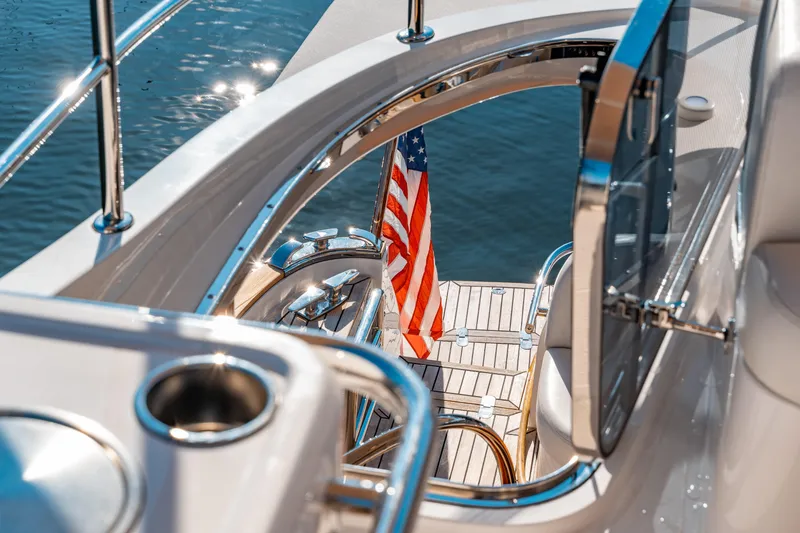 Yacht Photos Pics 2015 Belize 54 Daybridge yacht with American flag, viewed from deck, reflecting sunlight on water.
