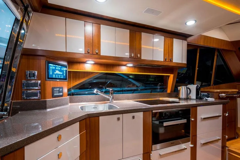  Yacht Photos Pics Luxurious kitchen interior of 2015 Belize 54 Daybridge yacht with modern appliances and wood cabinetry.