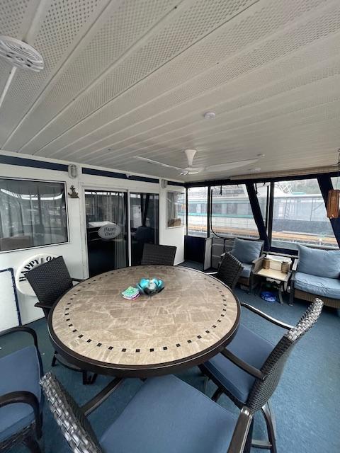 Spacious interior of 2000 Funtime 16x72 houseboat with round table and seating.