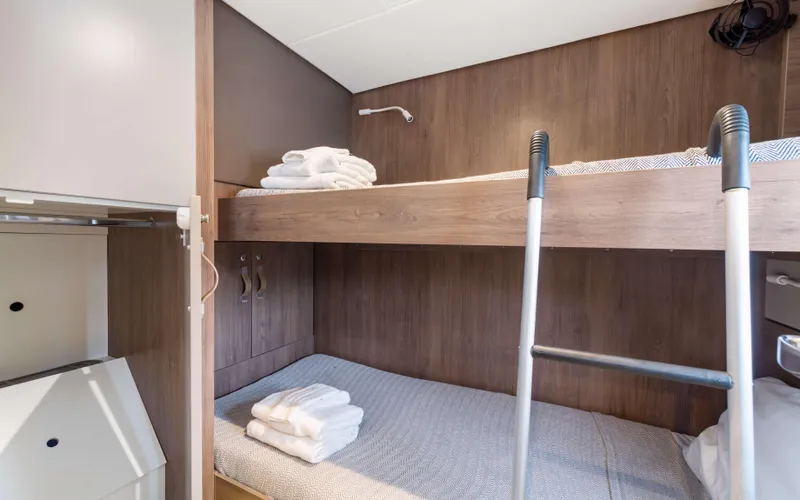Always Sunday Yacht Photos Pics Bunk beds in a 2022 Bali 4.8 yacht cabin with wooden interior and ladder.