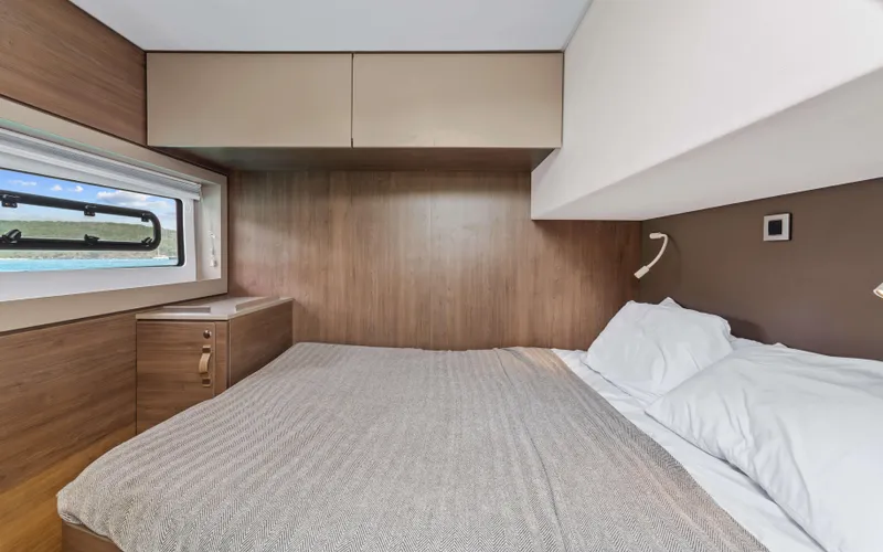 Always Sunday Yacht Photos Pics Luxurious cabin interior of 2022 Bali 4.8 yacht with cozy bed and scenic window view.